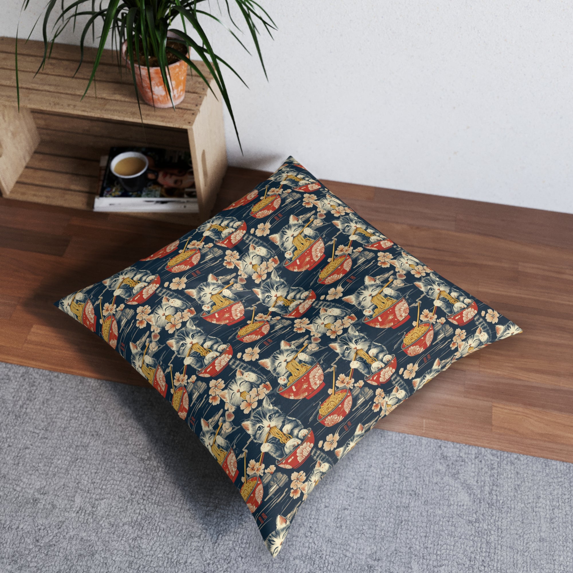 Indoor Square Floor Pillow - A charming and detailed illustration of happy kittens in red ramen bowls eating their noodles with chopsticks among beautiful pink cherry blossoms on a dark background.