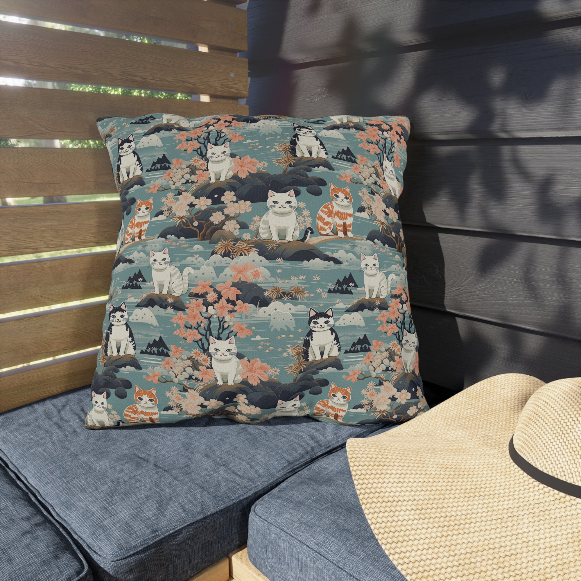 Outdoor Pillow - A serene watercolor painting of fluffy cats lounging on rocks, surrounded by cherry blossoms and blue water, in a tranquil, nature-filled, Japanese-inspired landscape.