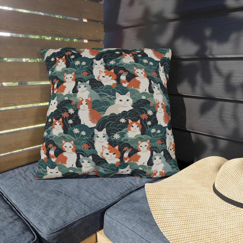 Outdoor Pillow - A whimsical, fluffy, watercolor depiction of various cats of different colors peeking out from a dense dark blue and green bush with white flowers.