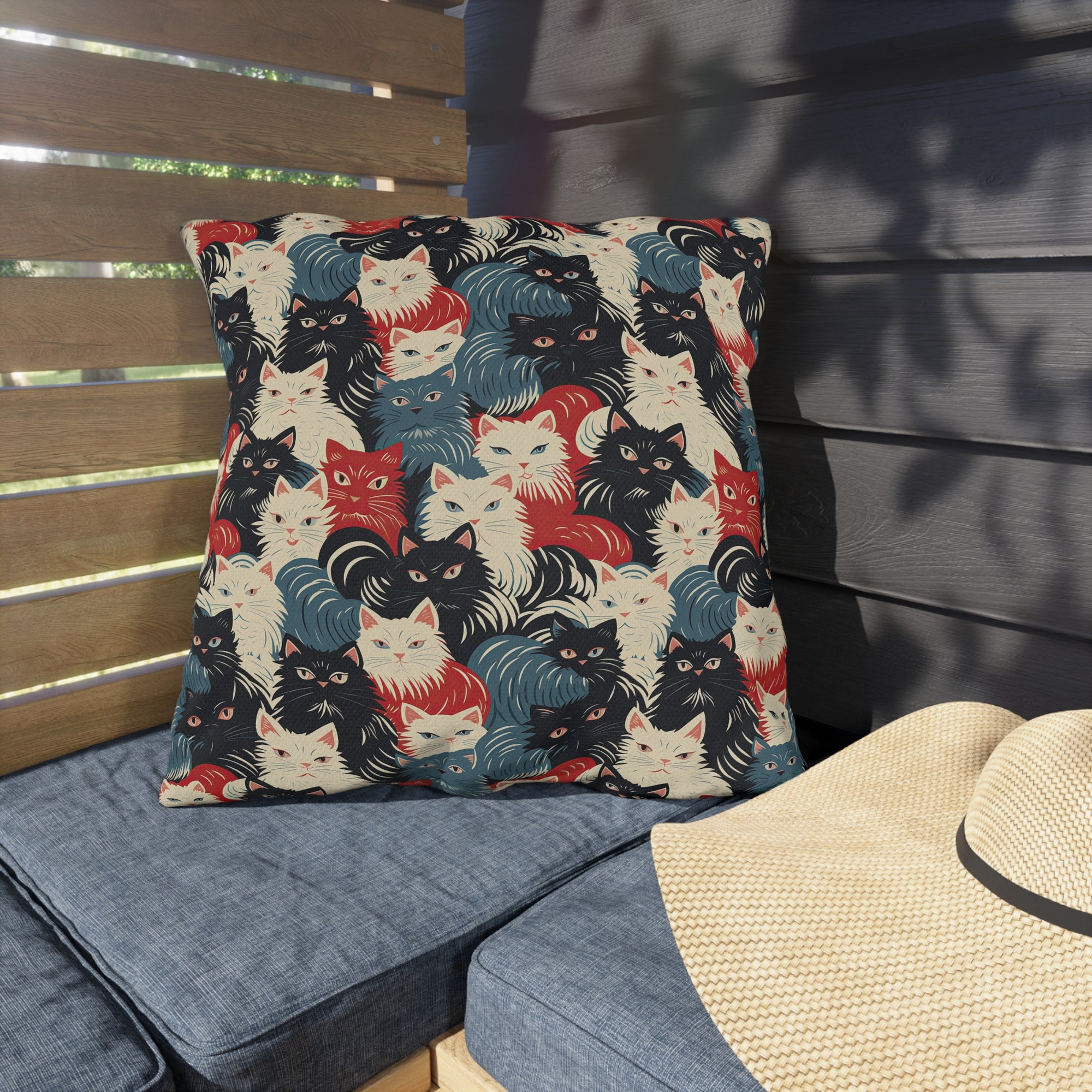 Outdoor Pillow - A bold and graphic pop art style illustration featuring a tight-knit cluster of various fluffy felines in black, white, red, and blue.