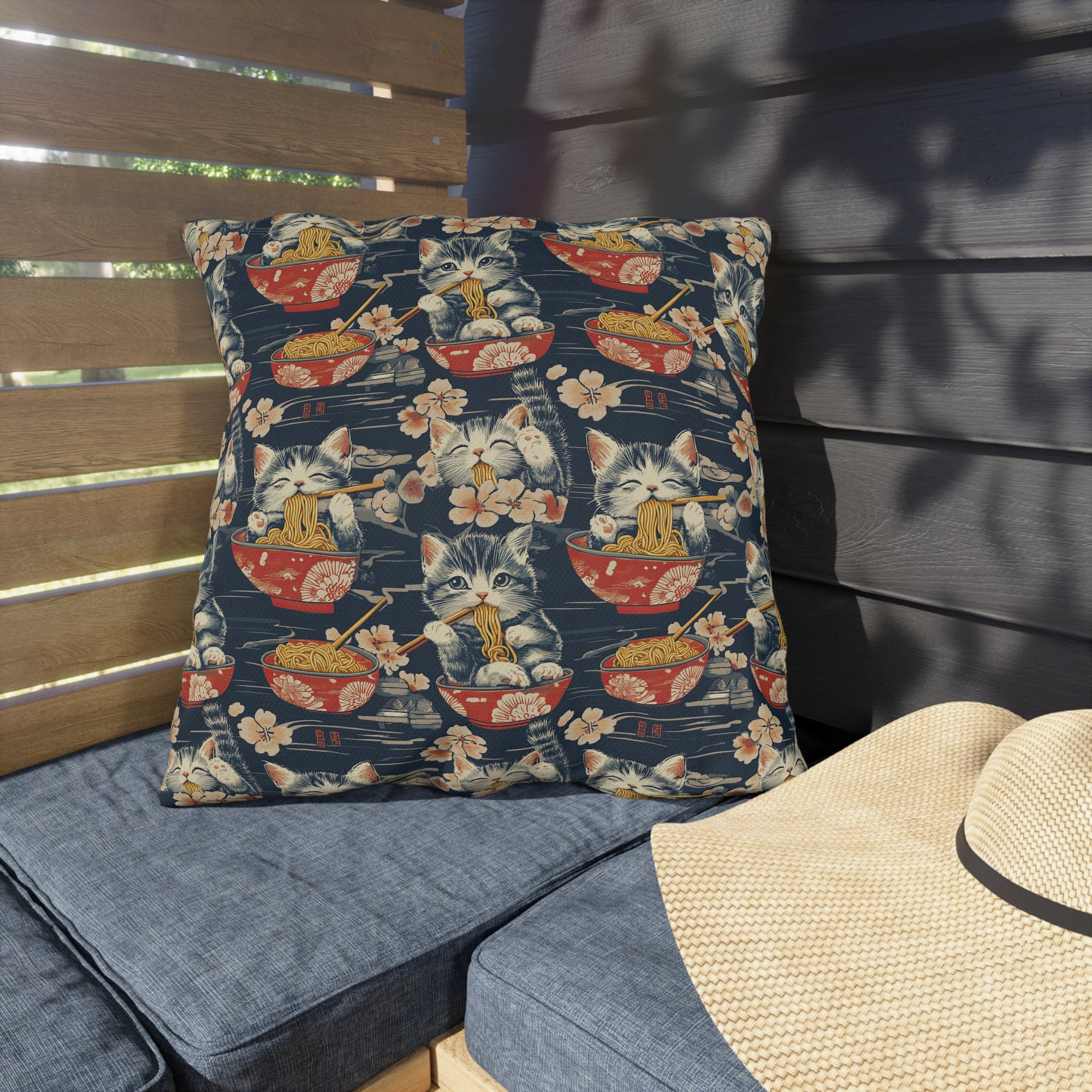 Outdoor Pillow - A charming and detailed illustration of happy kittens in red ramen bowls eating their noodles with chopsticks among beautiful pink cherry blossoms on a dark background.
